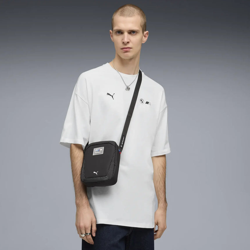 Black Puma shoulder bag worn by model.